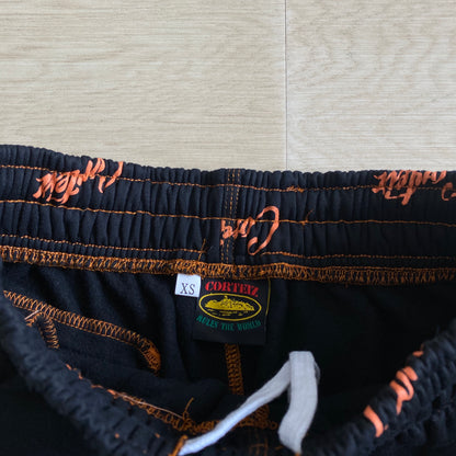 Corteiz All Over Print Joggers Black Orange